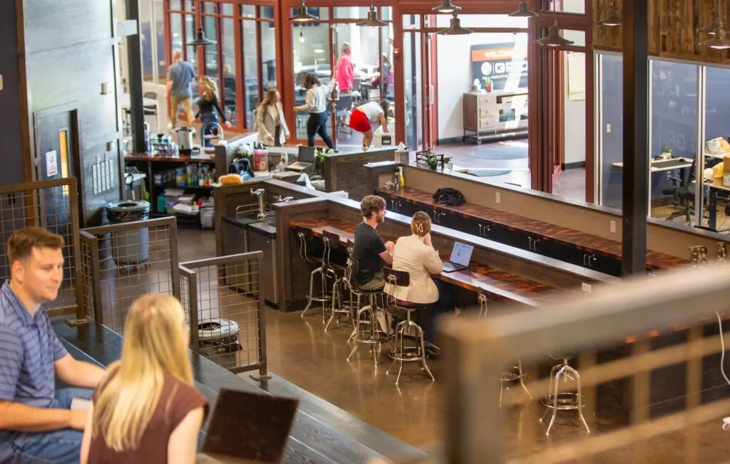 People working on laptops in common areas of GRID Collaborative Workspaces in Overland Park