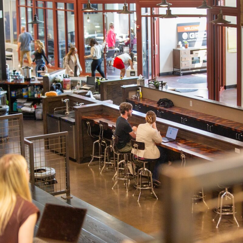 People working on laptops in common areas of GRID Collaborative Workspaces in Overland Park